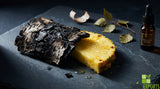 A macro photograph of charred birch bark resting next to a freshly sliced, juicy pineapple on a dark slate surface, dramatic side lighting, fine dining aesthetic, shallow depth of field